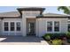 Close up of the front entrance featuring a paver walkway and lush garden beds at 6172 Lungo Lago Dr, Sarasota, FL 34241