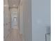 Clean hallway with white trim and doors, leading to a bathroom, highlighting the home's modern design at 6172 Lungo Lago Dr, Sarasota, FL 34241