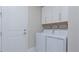 Laundry room featuring side-by-side washer and dryer with storage and shelving at 6172 Lungo Lago Dr, Sarasota, FL 34241