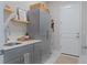 Laundry room featuring a sink, storage cabinets, wood shelving and decor at 6172 Lungo Lago Dr, Sarasota, FL 34241