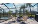 Screened-in patio with relaxing seating looking out to the pool, spa, and backyard at 6172 Lungo Lago Dr, Sarasota, FL 34241