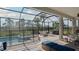 A screened-in pool and patio with dining and relaxing seating and backyard views at 6172 Lungo Lago Dr, Sarasota, FL 34241