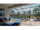 A screened-in pool and patio with seating and views of the backyard and lush landscaping at 6172 Lungo Lago Dr, Sarasota, FL 34241