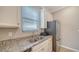 Well-lit kitchen features stainless steel appliances, double sink, granite countertops, and white cabinets at 6410 Rosehill Farm Run, Bradenton, FL 34211