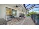 Covered outdoor patio with brick floors, ceiling fans, and comfortable seating area, perfect for entertaining at 6410 Rosehill Farm Run, Bradenton, FL 34211