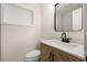 Updated half-bath features modern wood cabinet, white marble countertop, black hardware, and custom shelving at 6639 16Th N St, St Petersburg, FL 33702