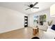 Bright living room featuring a contemporary front door, large window, and modern ceiling fan at 6639 16Th N St, St Petersburg, FL 33702