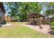 Backyard of log home with a wooden gazebo with a table and chairs set on a stone-paved surface at 6811 6Th W St, Bradenton, FL 34207
