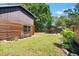 Backyard of log home, including a pergola on a paved surface with a garden at 6811 6Th W St, Bradenton, FL 34207