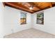 Bright bedroom with tile flooring, two windows, and natural wood beam ceilings at 6811 6Th W St, Bradenton, FL 34207