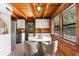 Dining area features a bright window, modern table set, rustic log walls, and tile floors at 6811 6Th W St, Bradenton, FL 34207