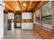 Dining area features a bright window, white cabinets, rustic log walls, and tile floors at 6811 6Th W St, Bradenton, FL 34207