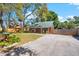 Charming log cabin showing the side of the home with fenced in yard and a long driveway at 6811 6Th W St, Bradenton, FL 34207