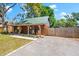 Charming log cabin showing the side of the home with fenced in yard and a long driveway at 6811 6Th W St, Bradenton, FL 34207
