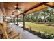 Inviting front porch with ceiling fans and rocking chairs overlooking the fenced in yard at 6811 6Th W St, Bradenton, FL 34207