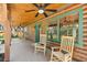 Inviting front porch with ceiling fans and rocking chairs, perfect for relaxing outdoors at 6811 6Th W St, Bradenton, FL 34207