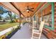 Inviting front porch with ceiling fans and rocking chairs overlooking the fenced in yard at 6811 6Th W St, Bradenton, FL 34207