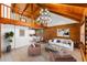 Spacious living room features vaulted ceilings, hardwood floors, a modern chandelier, and rustic log walls at 6811 6Th W St, Bradenton, FL 34207