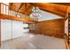 Spacious living room features vaulted ceilings, hardwood floors, a modern chandelier, and rustic log walls at 6811 6Th W St, Bradenton, FL 34207