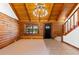 Inviting living room showcases log walls, a beamed ceiling with modern lighting, and tile flooring at 6811 6Th W St, Bradenton, FL 34207