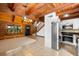 Open-concept living area with log walls, staircase, stainless refrigerator, and modern kitchen appliances at 6811 6Th W St, Bradenton, FL 34207
