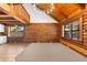 Spacious living room with hardwood floors, log walls, and ample natural light coming in from the windows at 6811 6Th W St, Bradenton, FL 34207