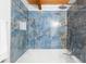 Close-up of the renovated shower featuring stylish blue tile and modern shower head at 6811 6Th W St, Bradenton, FL 34207