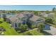 Aerial view of a beautiful home featuring a well-manicured lawn, lush landscaping, and serene lake views at 6915 Honeysuckle Trl, Lakewood Ranch, FL 34202