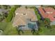 Aerial view of a house with a pool and tile roof surrounded by trees at 6915 Honeysuckle Trl, Lakewood Ranch, FL 34202