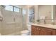 Clean bathroom featuring tiled shower with glass door, vanity, and artwork at 6915 Honeysuckle Trl, Lakewood Ranch, FL 34202