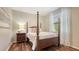 Bright bedroom features four-poster bed, hardwood floors, and soft, natural light at 6915 Honeysuckle Trl, Lakewood Ranch, FL 34202