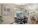 Cozy dining area with a round table, modern chandelier, and views of the pool and serene lake at 6915 Honeysuckle Trl, Lakewood Ranch, FL 34202