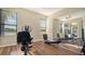 Bright exercise room with hardwood floors, exercise equipment, and mirrored wall at 6915 Honeysuckle Trl, Lakewood Ranch, FL 34202