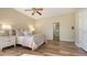 Main bedroom suite boasts hardwood flooring, ceiling fan, and access to bathroom at 6915 Honeysuckle Trl, Lakewood Ranch, FL 34202
