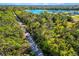 Picturesque aerial view of a property surrounded by lush greenery, a pond, and mature trees at 7713 Fairway Woods Dr # 902, Sarasota, FL 34238