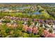 Overhead view of lush landscaping, red tile roofs, and a serene lake, highlighting community features at 7713 Fairway Woods Dr # 902, Sarasota, FL 34238