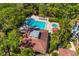 Aerial view of a home with a private pool, spa, patio and cabana surrounded by lush trees at 7713 Fairway Woods Dr # 902, Sarasota, FL 34238