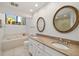 Bathroom featuring a soaking tub, granite counters, and a double sink vanity at 7713 Fairway Woods Dr # 902, Sarasota, FL 34238