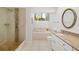 Bathroom featuring a glass door shower, soaking tub, and a single vanity with granite counters at 7713 Fairway Woods Dr # 902, Sarasota, FL 34238