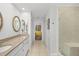 Bathroom hallway leading to the main bedroom featuring double sinks and a shower at 7713 Fairway Woods Dr # 902, Sarasota, FL 34238
