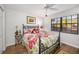 Charming bedroom with a wrought iron bed frame and colorful floral bedding with bright natural light at 7713 Fairway Woods Dr # 902, Sarasota, FL 34238