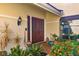 Close up of the front door with beautiful tropical landscaping and decor at 7713 Fairway Woods Dr # 902, Sarasota, FL 34238