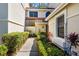 Charming two-story home featuring a well-manicured front yard with lush green landscaping and a paver walkway at 7713 Fairway Woods Dr # 902, Sarasota, FL 34238