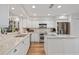 Bright kitchen featuring white cabinets, stainless appliances, quartz counters and wood flooring at 7713 Fairway Woods Dr # 902, Sarasota, FL 34238