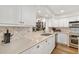 Kitchen featuring white cabinets, stainless appliances, quartz counters, and decorative backsplash at 7713 Fairway Woods Dr # 902, Sarasota, FL 34238