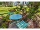 Cozy outdoor patio with a round aqua table and two chairs, nestled in a lush garden setting at 7713 Fairway Woods Dr # 902, Sarasota, FL 34238