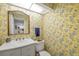 Unique powder room featuring a patterned wallpaper, a toilet and vanity, illuminated by a skylight at 7713 Fairway Woods Dr # 902, Sarasota, FL 34238
