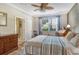 Comfortable bedroom featuring wood floors, a ceiling fan, and natural light through a window at 7979 Limestone Ln # 14-101, Sarasota, FL 34233