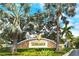 Community entrance with decorative stone signage, lush landscaping, and towering palm trees at 7979 Limestone Ln # 14-101, Sarasota, FL 34233