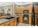 Well-equipped kitchen featuring black appliances, wood cabinets, and practical layout for efficient cooking at 7979 Limestone Ln # 14-101, Sarasota, FL 34233
